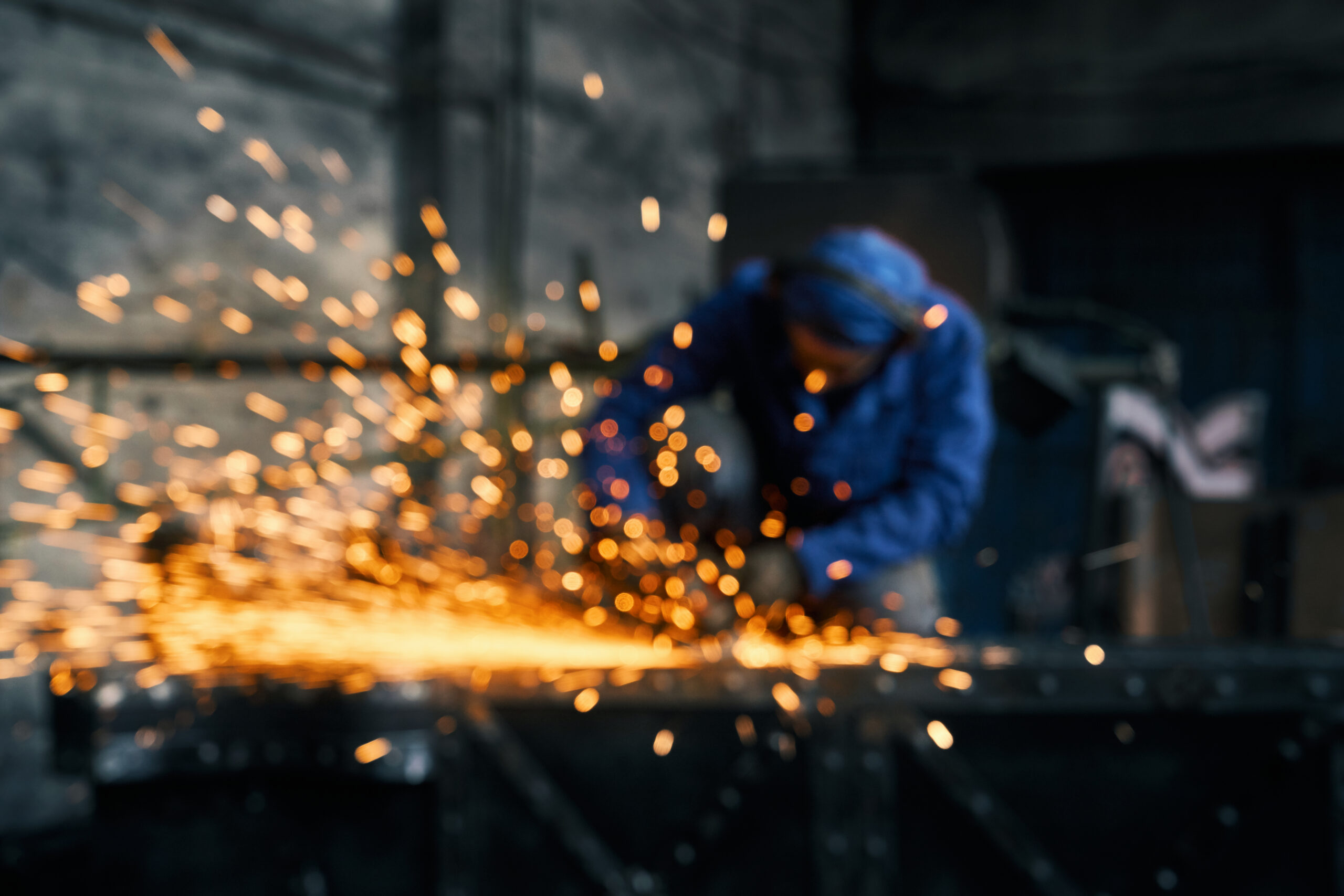 Worker doing gate by electric steel cutter machine.